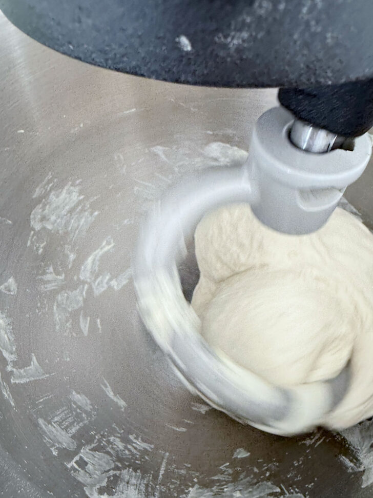 Pizza dough mixing in a stand mixer.
