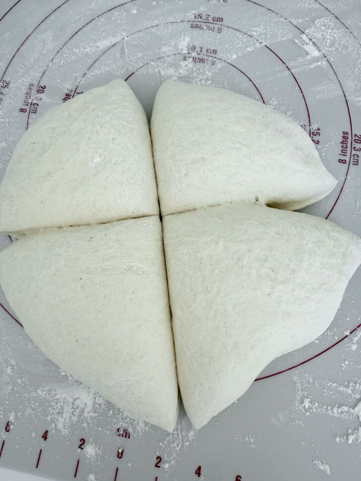 Pizza dough divided into 4 pieces.
