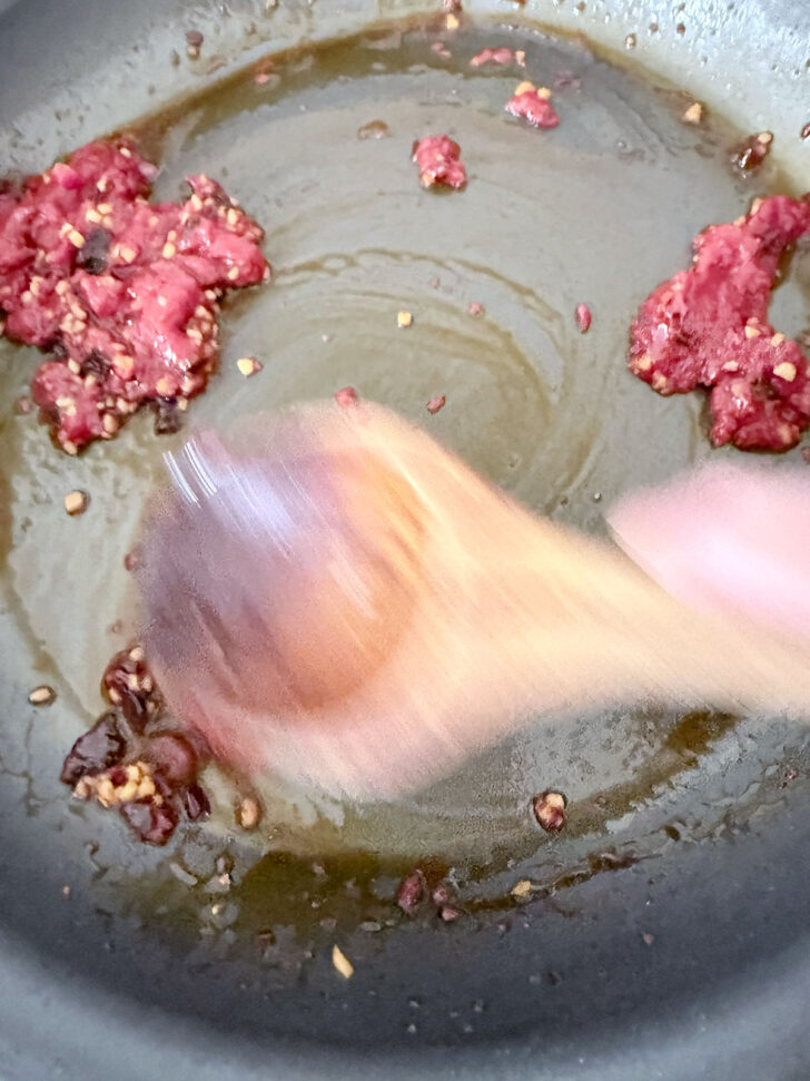 Cooking the tomato paste with the chili crisp and garlic.