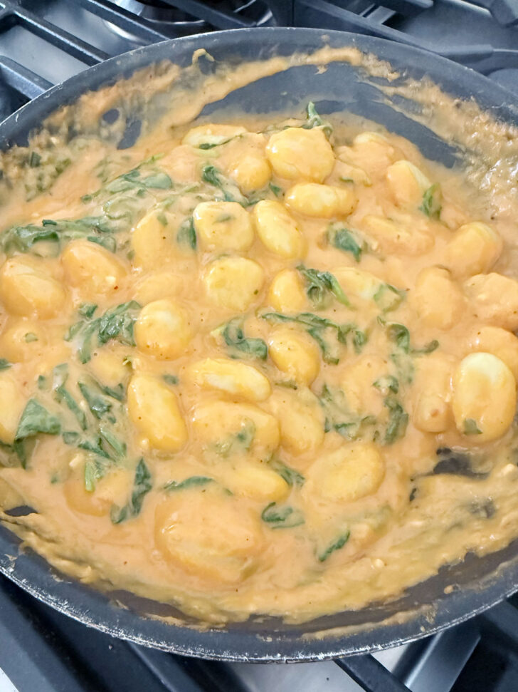 Finished gnocchi with butternut squash sauce in the skillet.