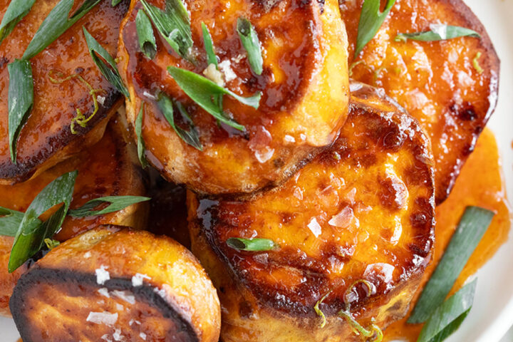 Melt sweet potatoes on a plate with honey sriracha sauce.