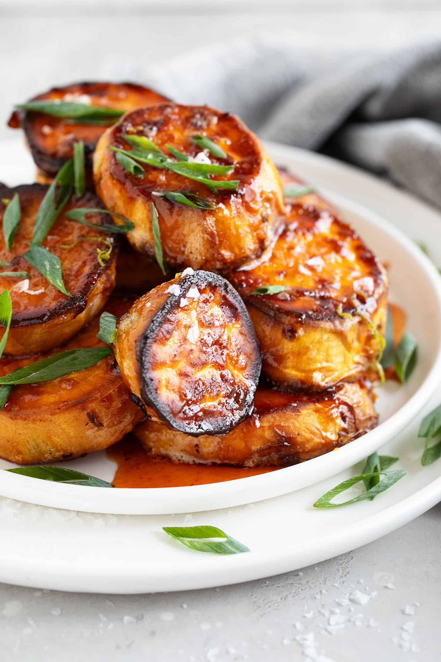 Honey Sriracha melts sweet potatoes on a plate.