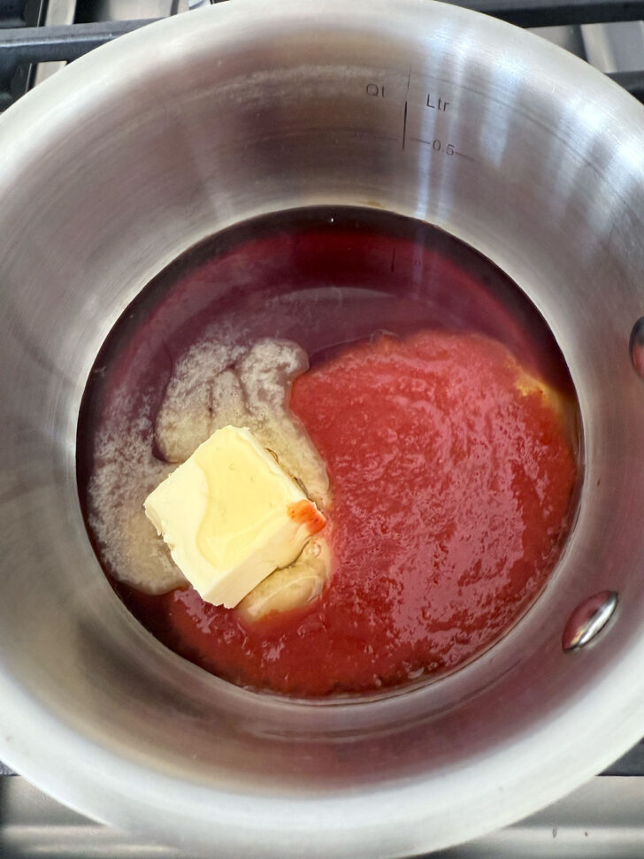 Honey sriracha sauce ingredients in a saucepan.