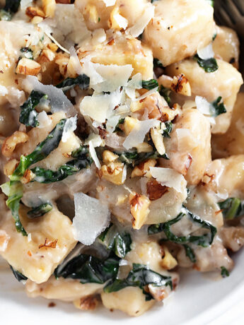 Pear and walnut gnocchi in serving bowl with a fork.
