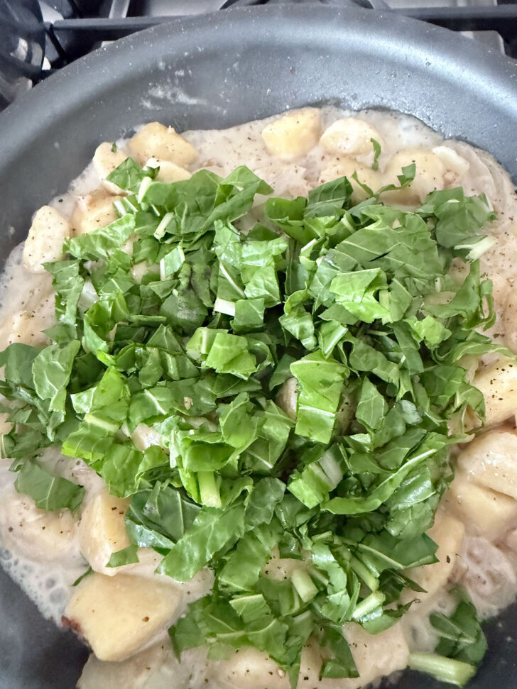 Adding chopped chard to the skillet.