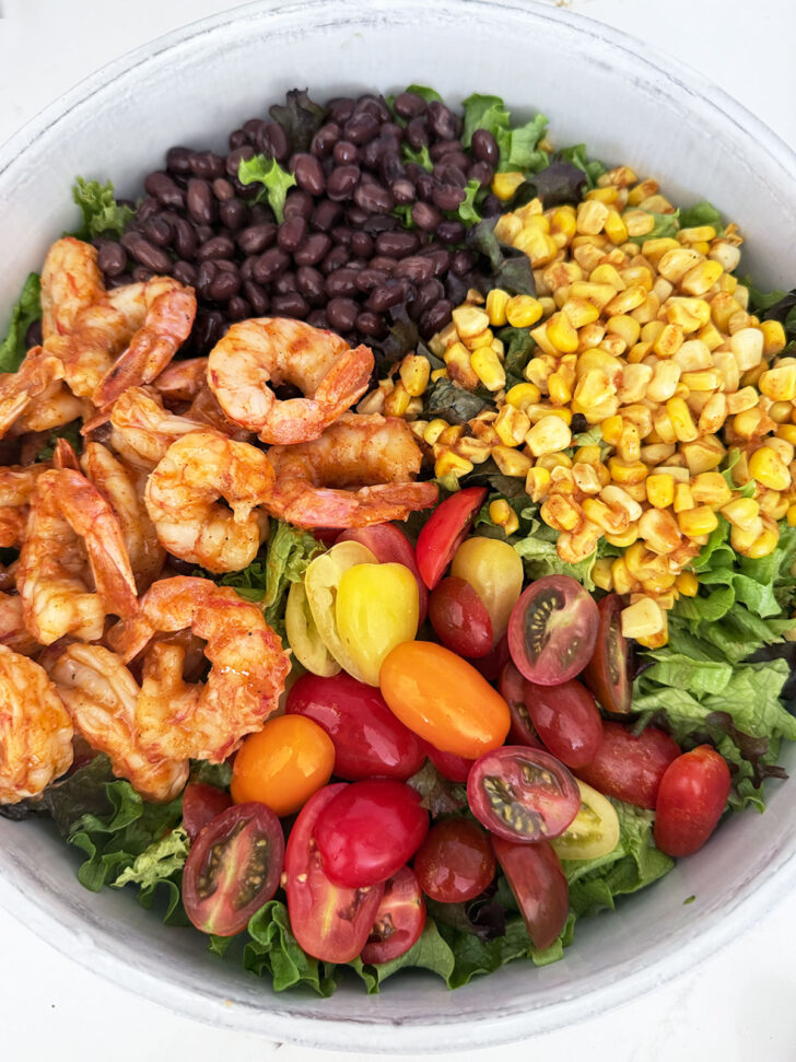Shrimp, corn, black beans and tomatoes added to the top of the lettuce.