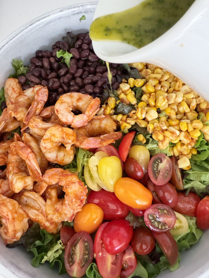 Drizzling the cilantro lime dressing over the salad.