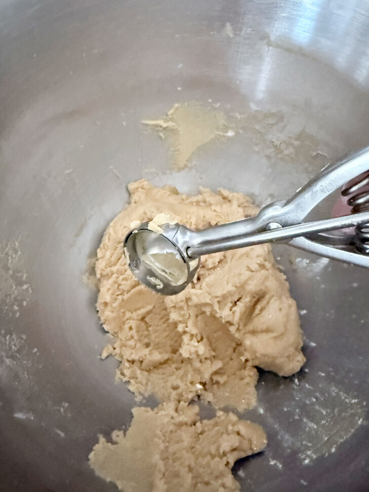 Using a cookie scoop to portion out the cookie dough.