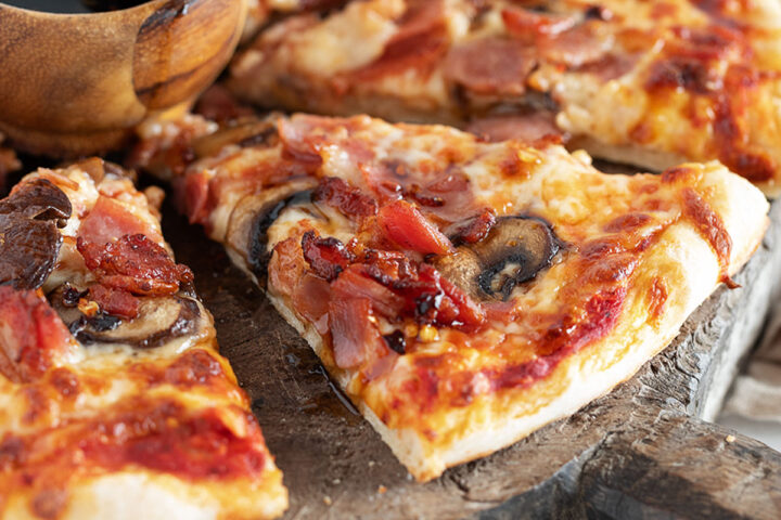 Classic Canadian pizza sliced ​​on a serving board.