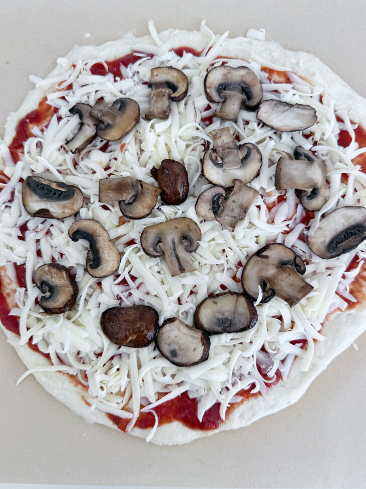 Pre-cooked mushrooms added to the top of the pizza.