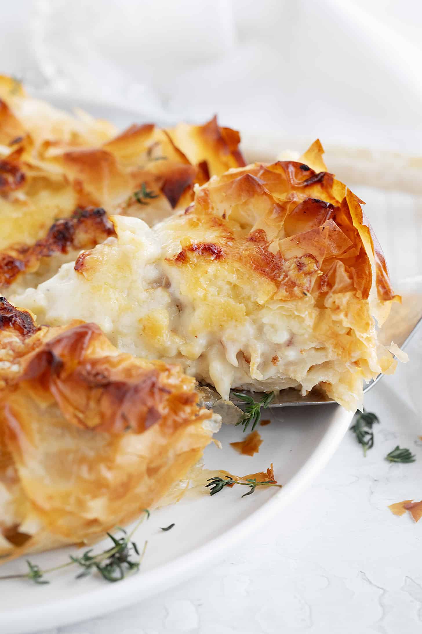 Cauliflower and cheese phyllo pie sliced on serving plate.