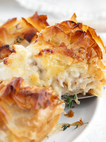 Cauliflower and cheese phyllo pie sliced on serving plate.
