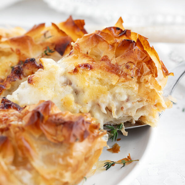 Cauliflower and cheese phyllo pie sliced on serving plate.
