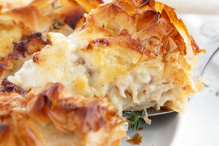 Cauliflower and cheese phyllo pie sliced on serving plate.