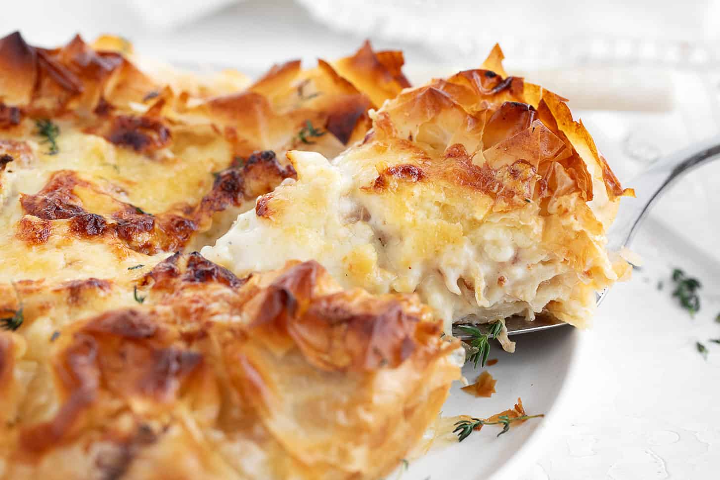 Cauliflower and cheese phyllo pie sliced on serving plate.