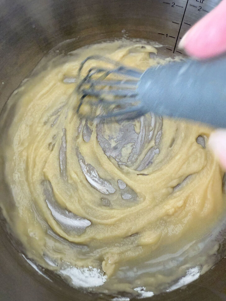 Whisking the melted butter and flour together.