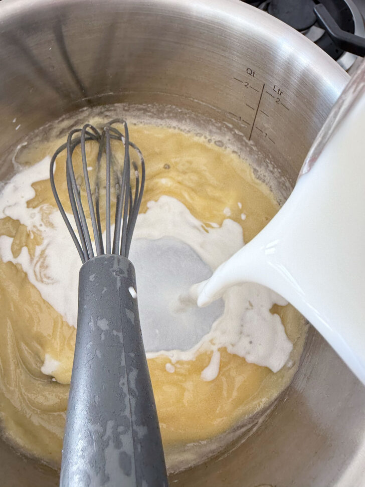 Adding the milk to the saucepan.