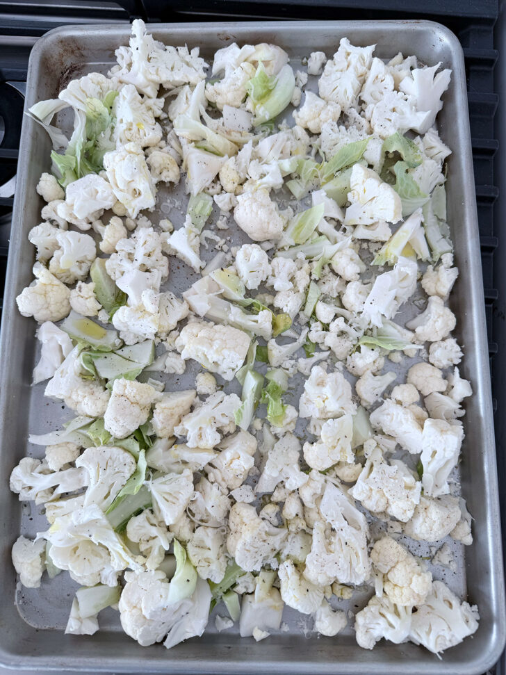 Chopped cauliflower on a baking sheet before roasting.