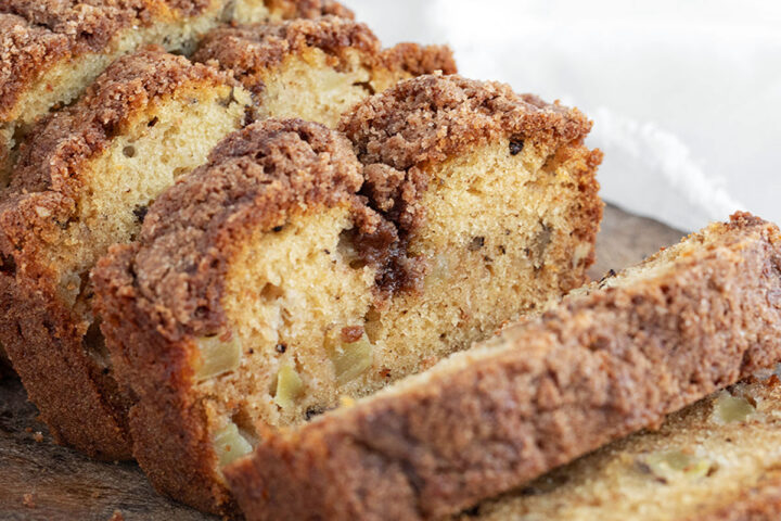Dutch apple loaf sliced on a cutting board.