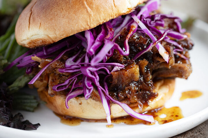 Maple mustard serves the pork on a bun and is served with shredded cabbage.