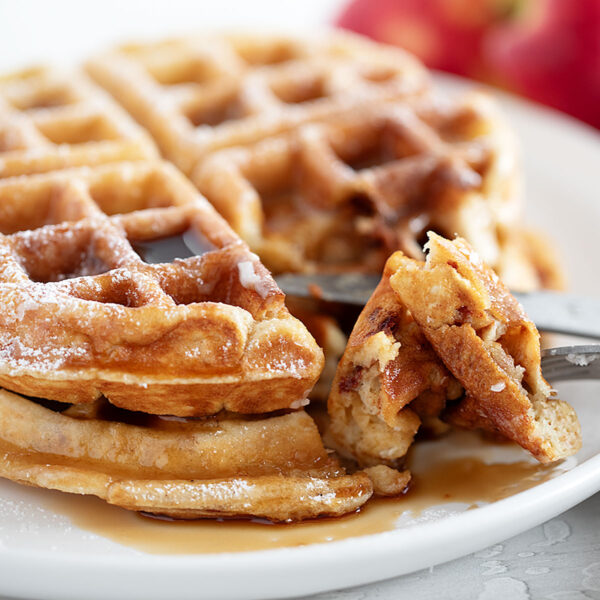 Apple fritter waffles on a plate with a fork.