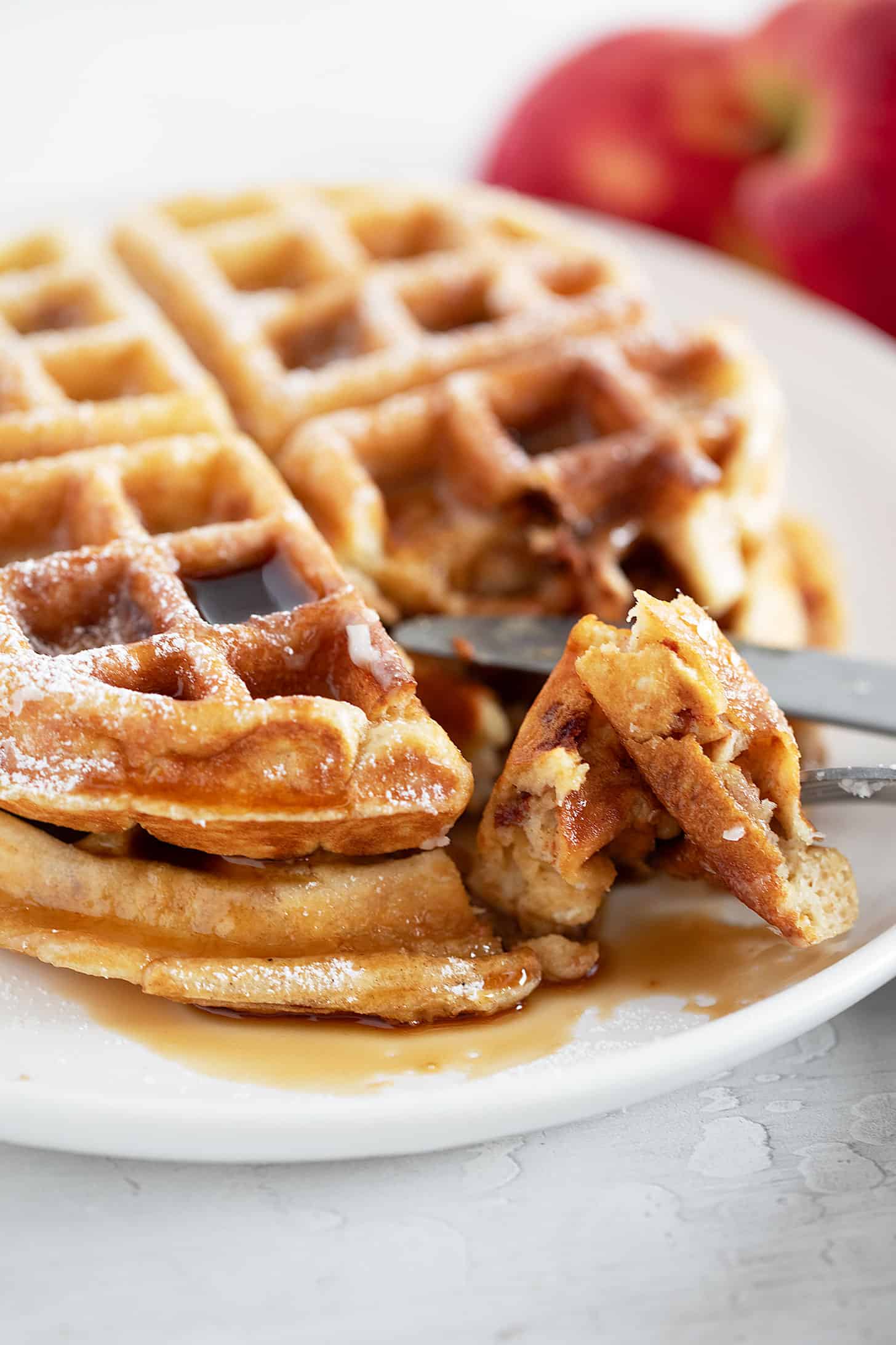 Apple fritter waffles on a plate with a fork.