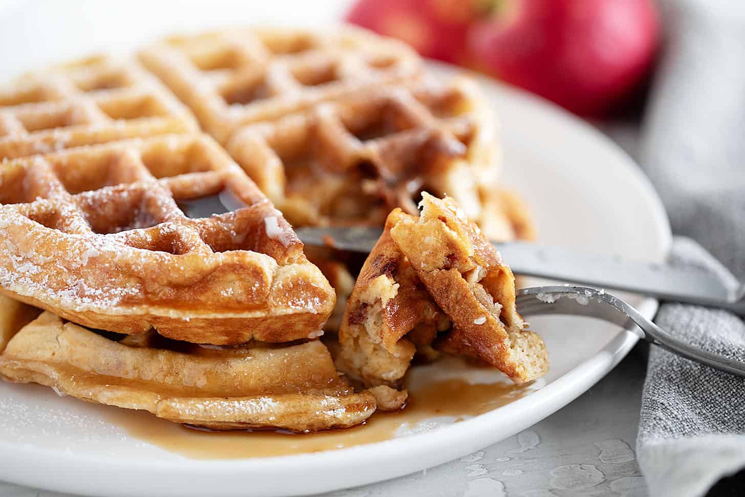 Apple fritter waffles on a plate with a fork.