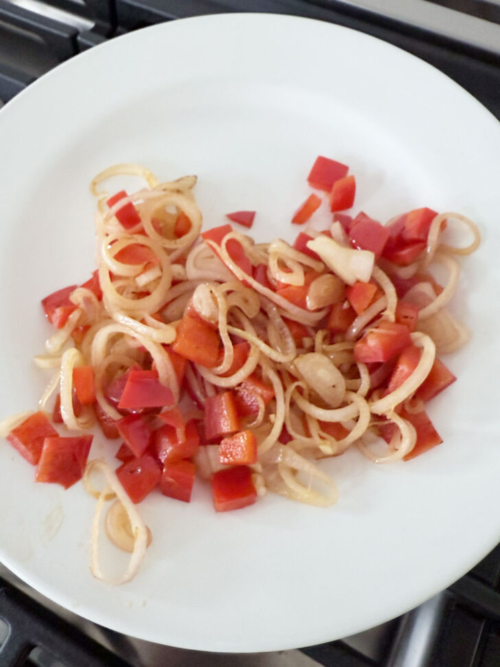 Cooked hallots and bell pepper removed to a plate.