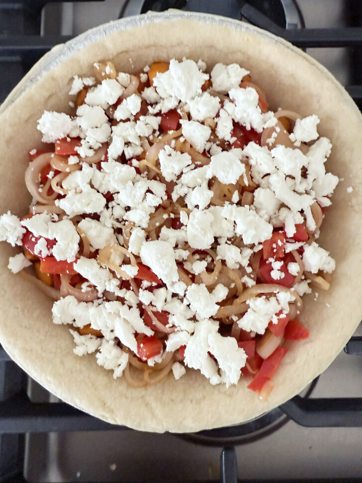 Shallots, bell pepper and goat cheese added to the pie shell.