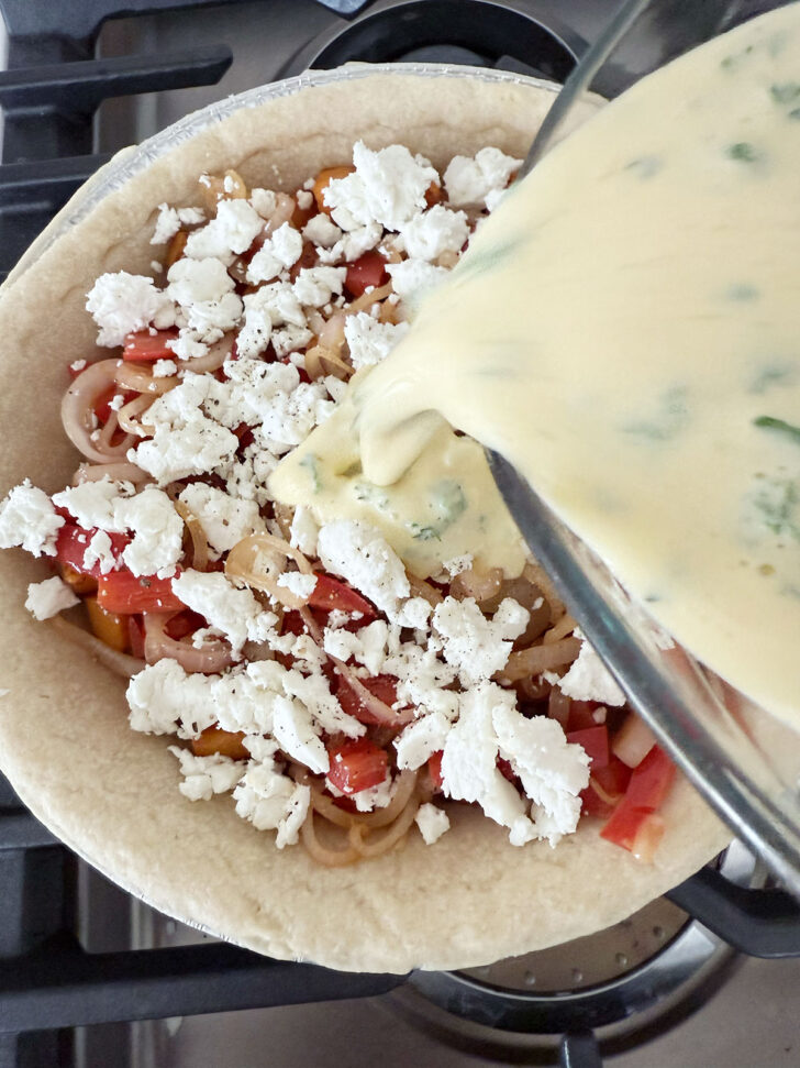 Pouring the egg mixture into the pie shell.