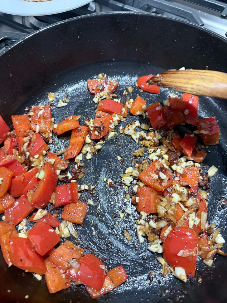 Onion, garlic and bell pepper cooking in a skillet,