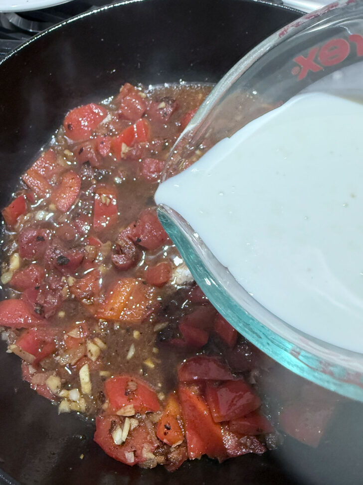 Adding cream to the skillet.