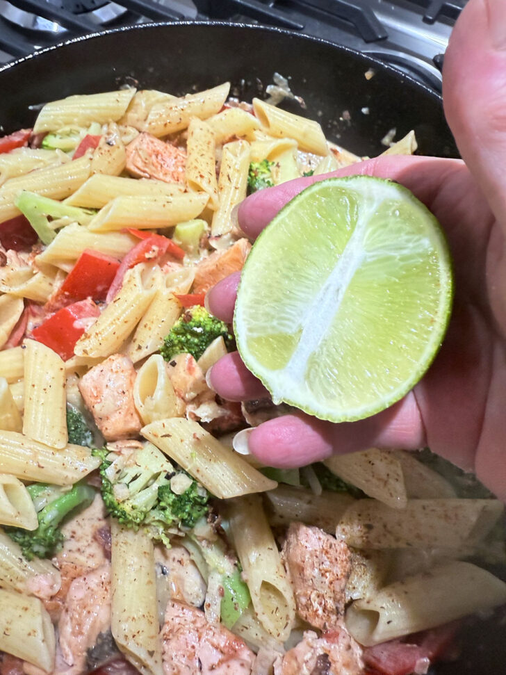 Finishing the cajun salmon pasta with fresh lime juice.