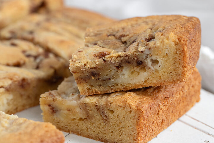 Cinnamon roll blondies cut on a wooden serving board.