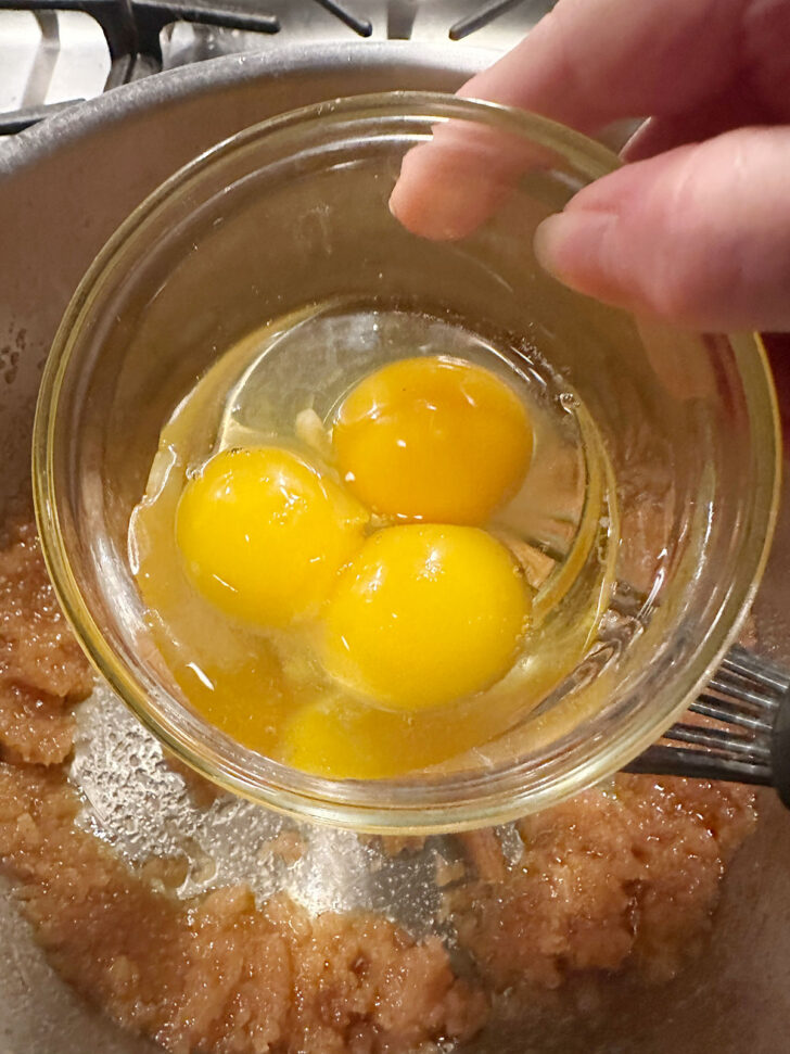 Adding eggs to the blondie batter,