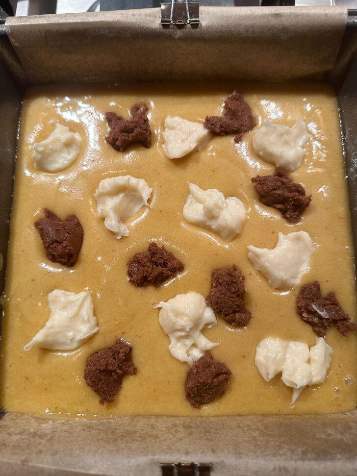 Cinnamon swirl and cream cheese swirl spooned on top of the batter,