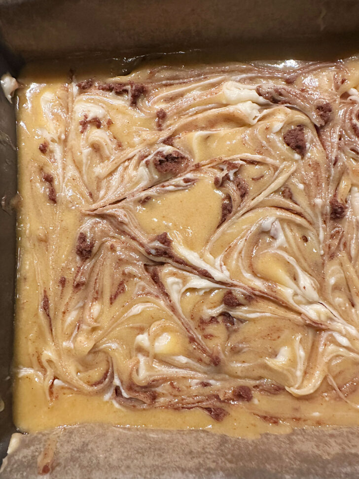 Cinnamon roll blondies after swirling in the cinnamon and cream cheese before baking.
