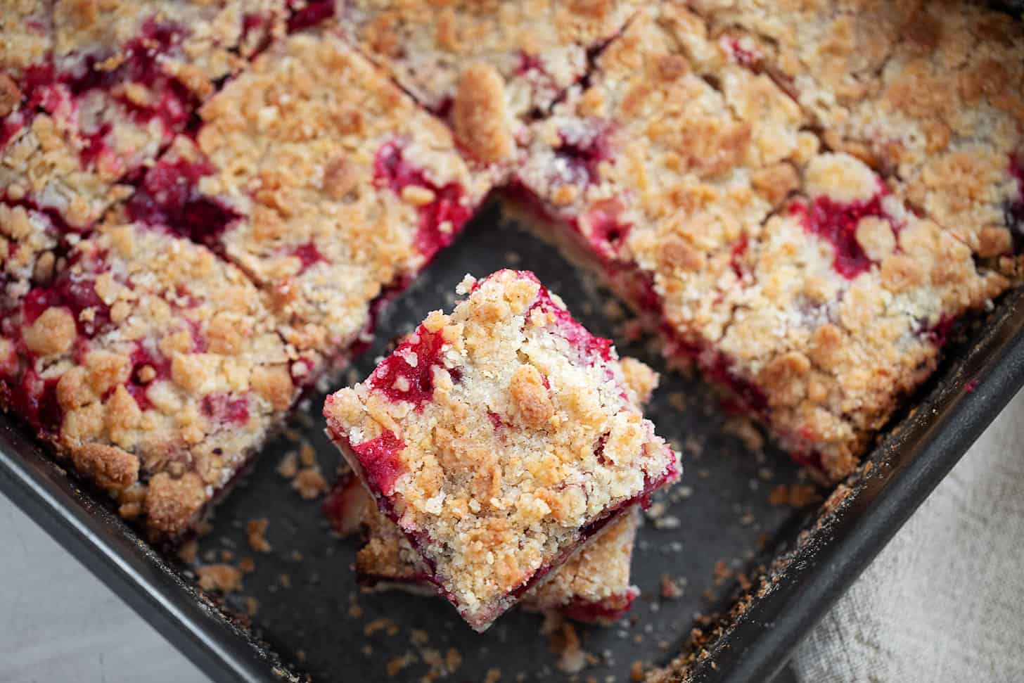 Cranberry crumb bars cut in baking pan.