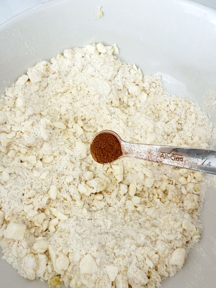 Adding cinnamon to the remaining crumb mixture.