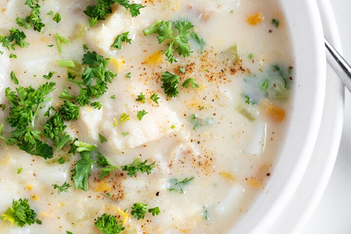 Cod chowder in a white bowl.