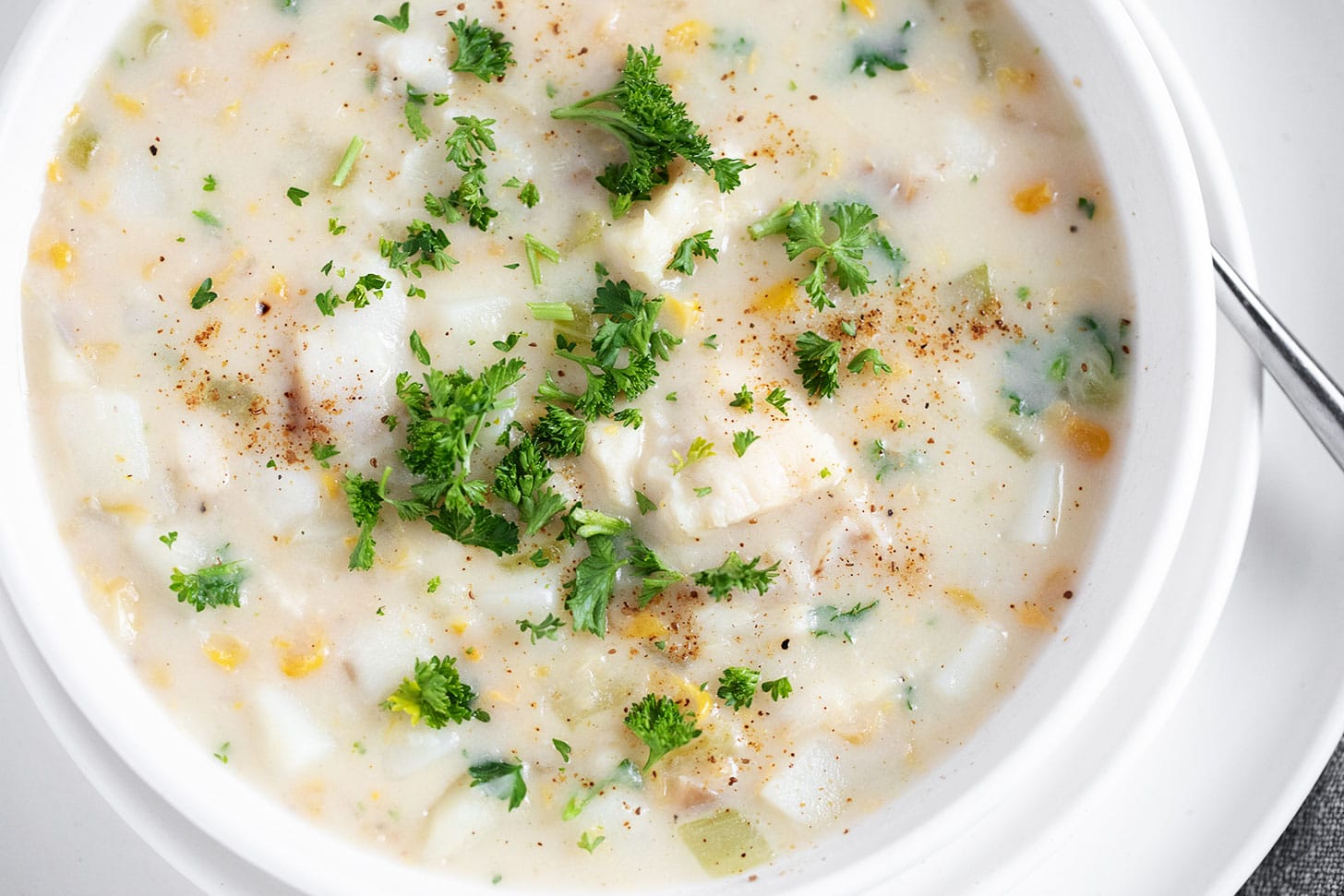 Cod chowder in a white bowl.