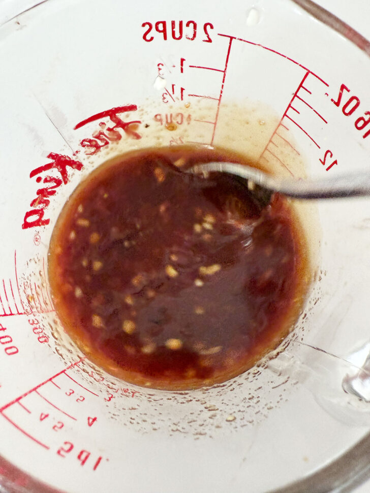 Mixing the marinade ingredients in a measuring cup.