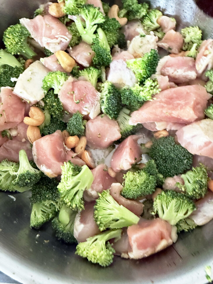 Cooking the broccoli, chicken pieces and cashews together.