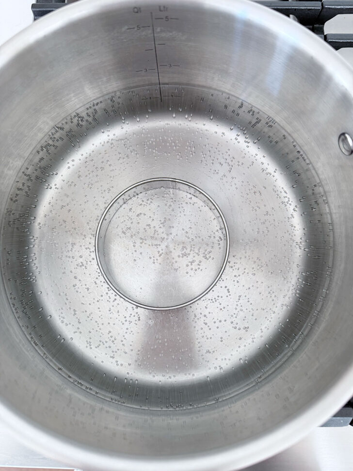 Pot of boiling water with a metal ring in the bottom of the pot to hold up the pudding,