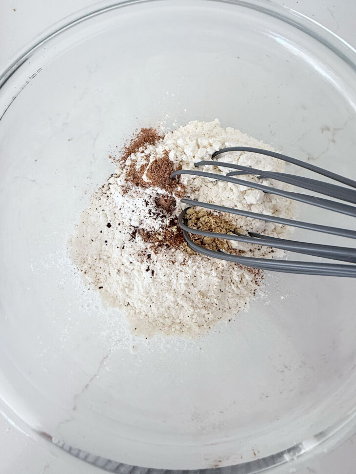 Dry ingredients in a bowl with a whisk.