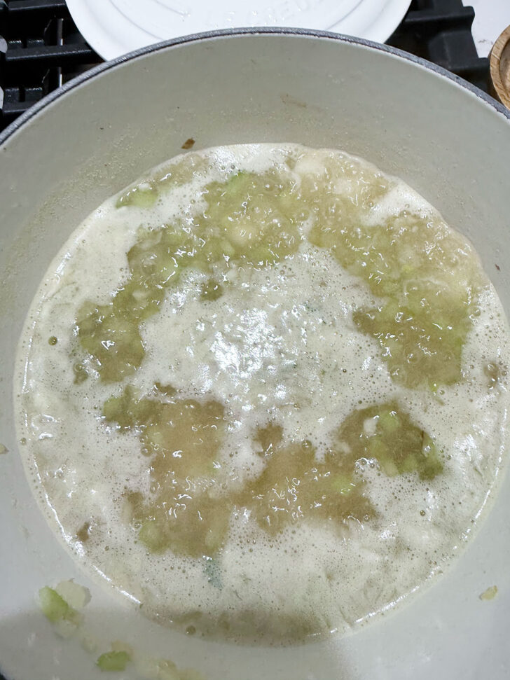Simmering the potatoes in broth.