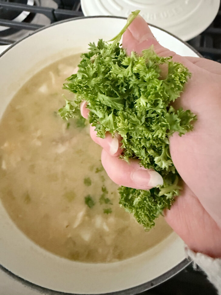 Adding chopped fresh parsley to the chowder.