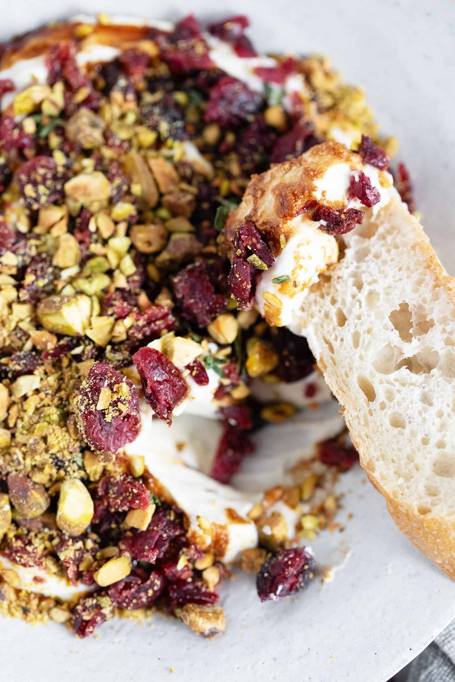 Cranberry balsamic whipped ricotta with a baguette slice.