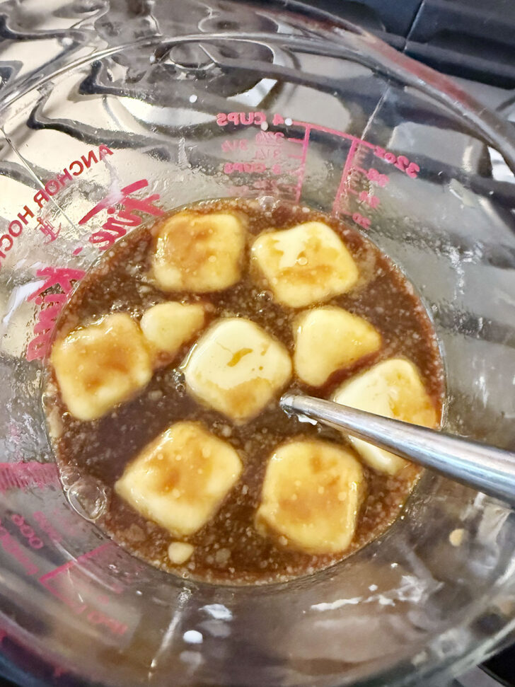 Butter melting with the milk mixture in a measuring cup.