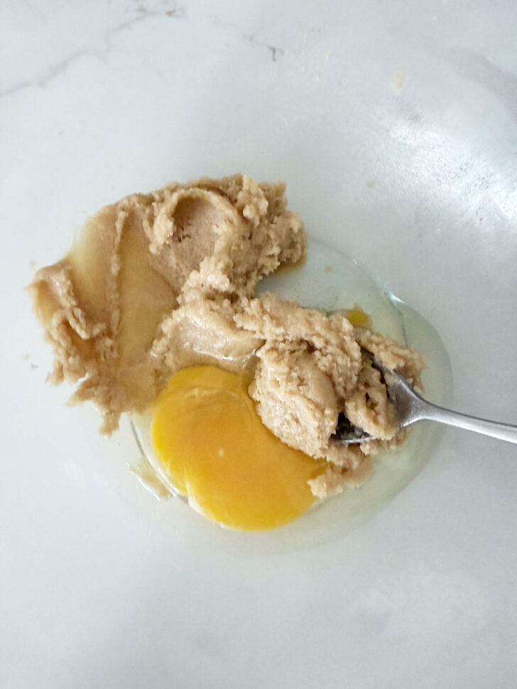 Adding the egg to the pudding. batter.